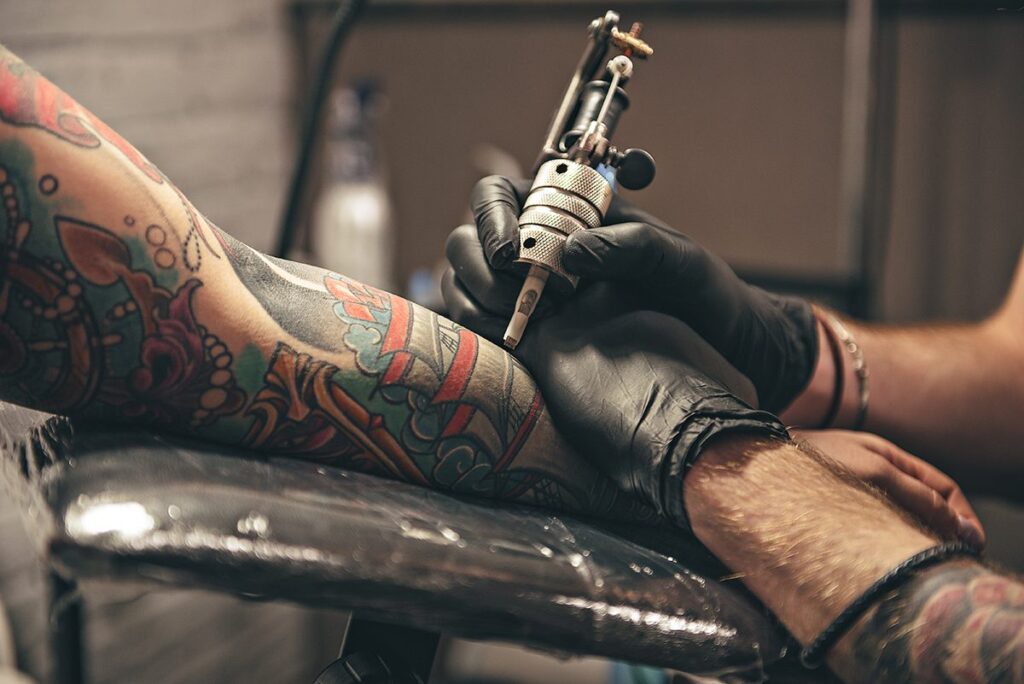 Close,Up,Tattoo,Machine.,Man,Creating,Picture,On,Hand,With